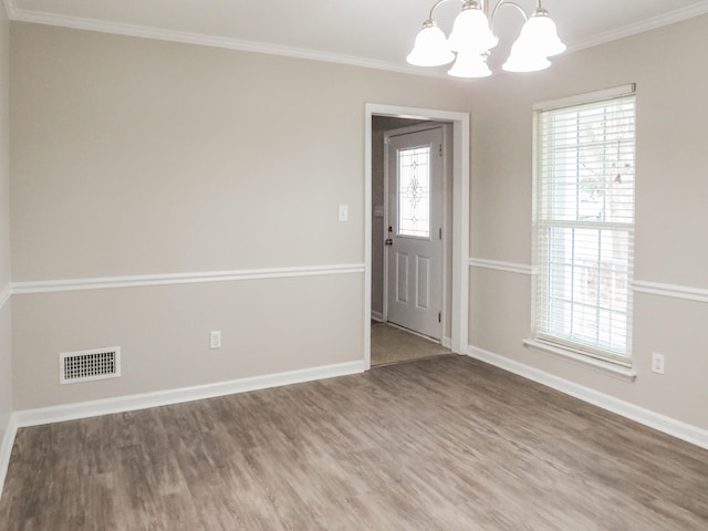 interior space featuring an inviting chandelier, ornamental molding, and hardwood / wood-style floors