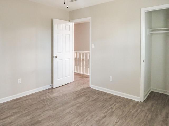 unfurnished bedroom with hardwood / wood-style floors and a closet