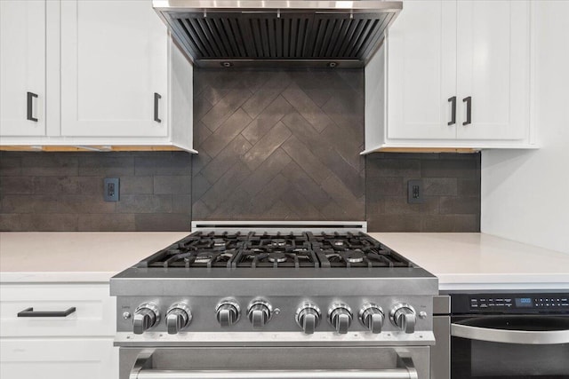 kitchen with exhaust hood, high end stainless steel range, white cabinetry, and light countertops