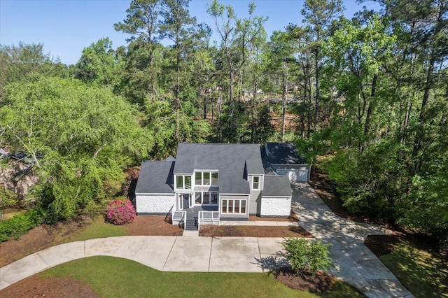 back of house featuring a shingled roof and a lawn