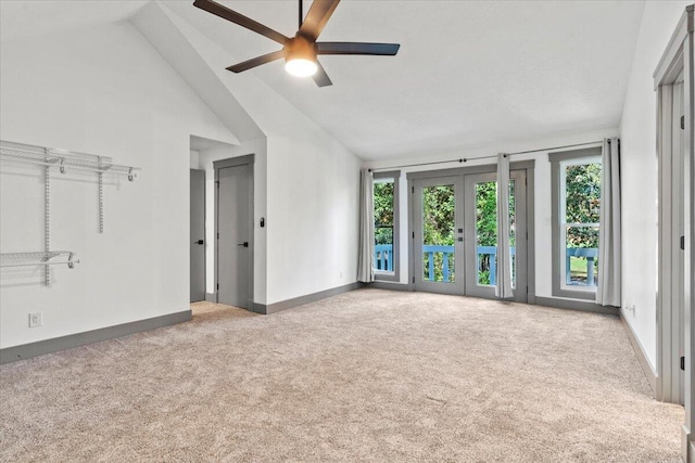 empty room with carpet flooring, baseboards, vaulted ceiling, and ceiling fan