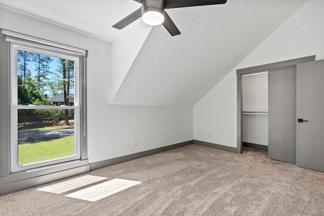 additional living space featuring carpet, lofted ceiling, ceiling fan, and baseboards