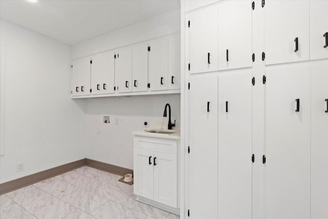 laundry area featuring baseboards, cabinet space, hookup for a washing machine, and light marble finish floors