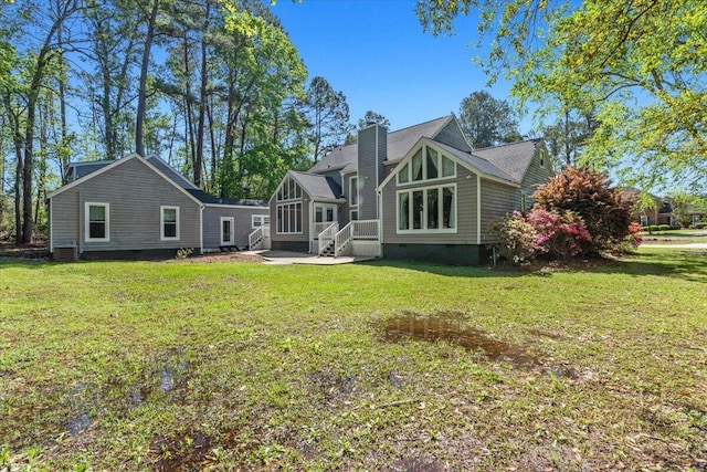 back of property with crawl space, a chimney, a lawn, and a sunroom