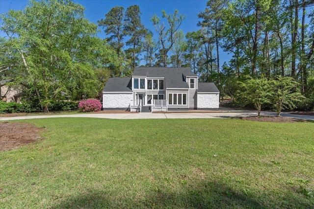 rear view of house featuring a yard