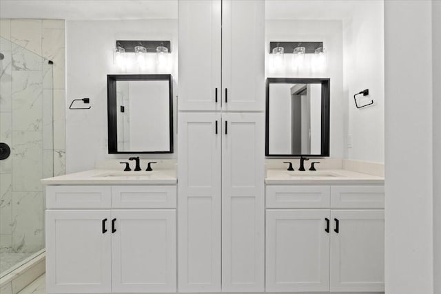 bathroom featuring a marble finish shower and vanity