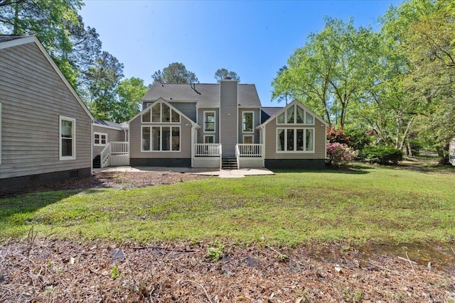 back of house featuring a patio, a chimney, a lawn, a deck, and crawl space