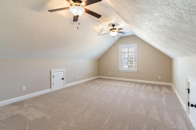 bonus room with carpet flooring, a textured ceiling, ceiling fan, and lofted ceiling