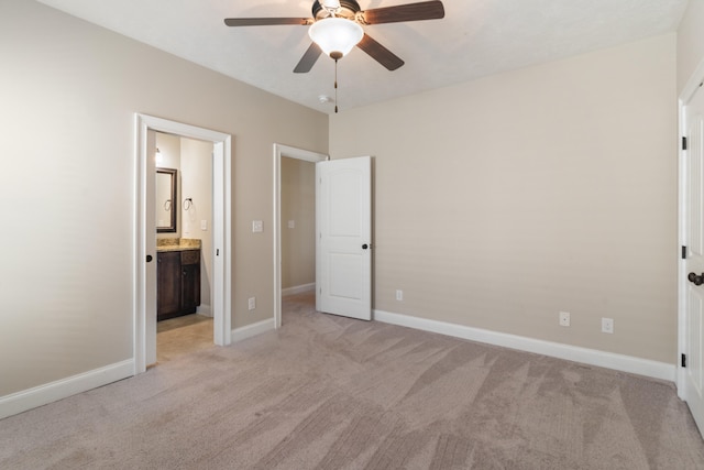 unfurnished bedroom with ceiling fan, light colored carpet, and ensuite bath