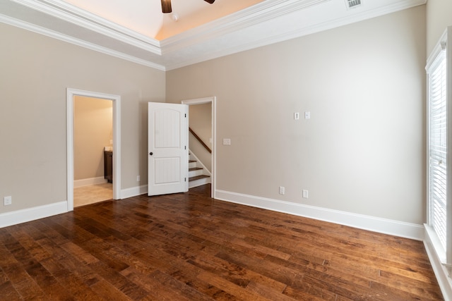 unfurnished room featuring dark hardwood / wood-style floors, ceiling fan, a raised ceiling, and crown molding