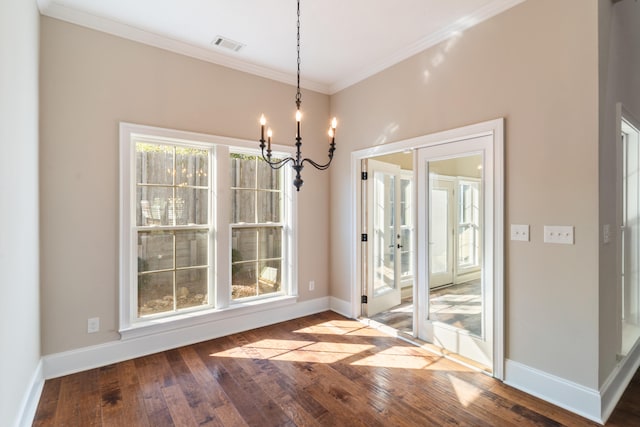 unfurnished dining area featuring crown molding, french doors, hardwood / wood-style floors, and a notable chandelier