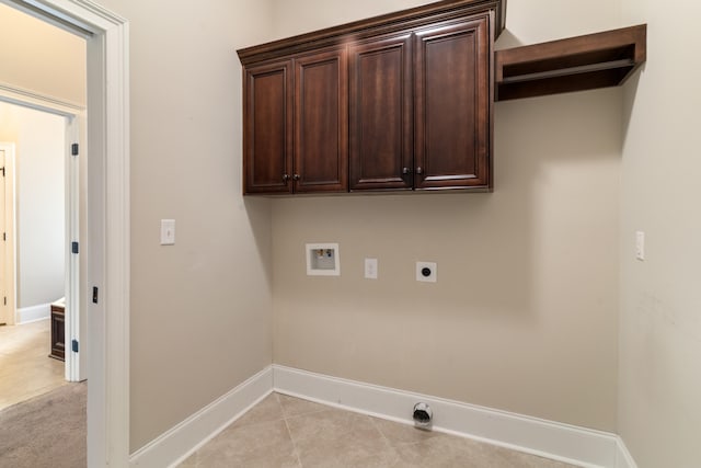 laundry area featuring hookup for an electric dryer, washer hookup, light tile patterned floors, and cabinets