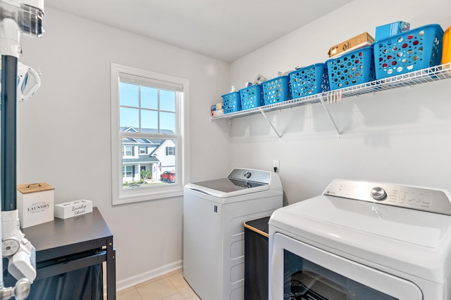 clothes washing area featuring laundry area, baseboards, independent washer and dryer, and light tile patterned floors