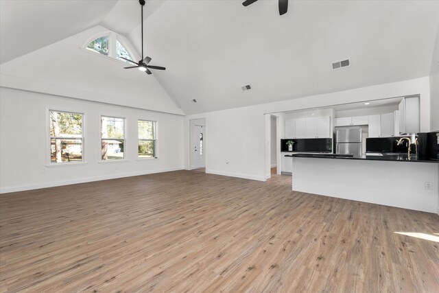 321 Padrick St, Martinez, GA 30907 - unfurnished living room featuring ceiling fan, high vaulted ceiling, healthy amount of natural light, light wood-type flooring, and baseboards