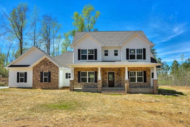 modern farmhouse style home featuring covered porch and a front lawn