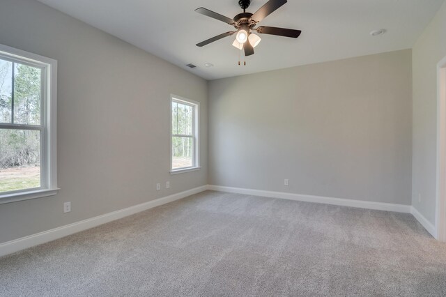 carpeted spare room featuring ceiling fan