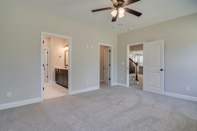 unfurnished bedroom featuring ensuite bathroom, ceiling fan, and light colored carpet