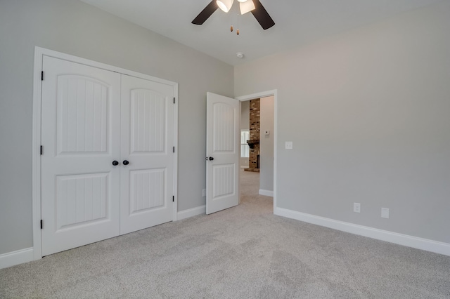 unfurnished bedroom featuring ceiling fan, a closet, and light carpet