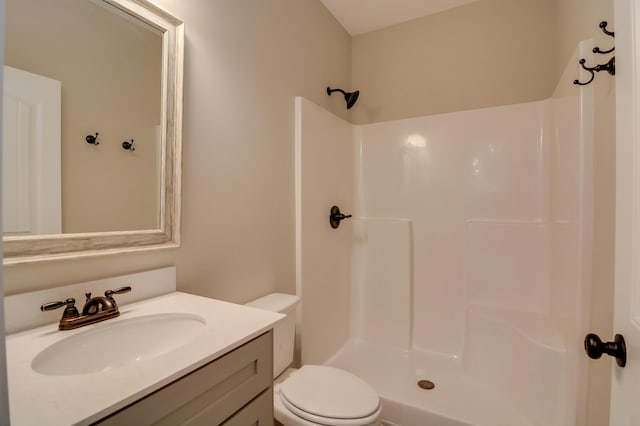 bathroom featuring vanity, toilet, and walk in shower