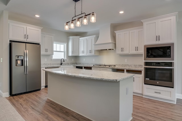 kitchen with custom exhaust hood, a center island, decorative light fixtures, white cabinetry, and stainless steel appliances