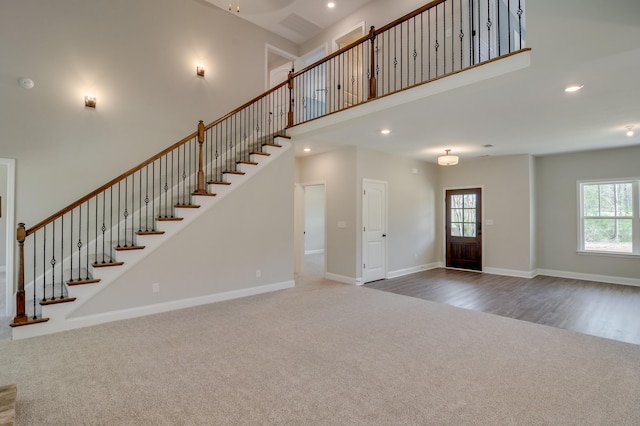 interior space featuring carpet, a high ceiling, and a healthy amount of sunlight