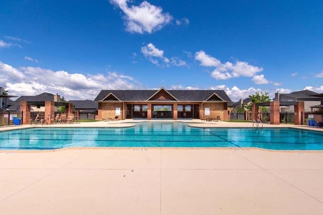 community pool featuring a patio and fence