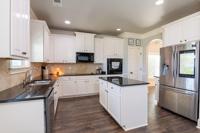 kitchen with a sink, arched walkways, visible vents, ornamental molding, and black appliances