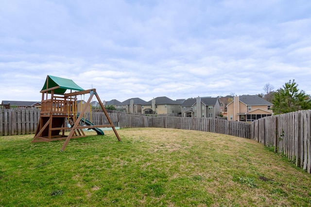 view of yard with a fenced backyard, a playground, and a residential view