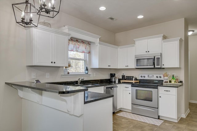 kitchen featuring stainless steel appliances, decorative light fixtures, white cabinets, and kitchen peninsula