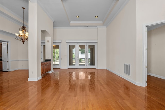 4120 Shady Oaks Dr, Martinez, GA 30907 - unfurnished living room featuring light wood-style flooring, arched walkways, a chandelier, and ornamental molding