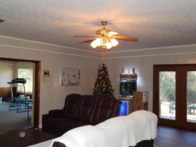 living room with ceiling fan, crown molding, and a textured ceiling