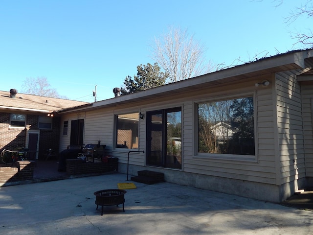 view of front facade with a fire pit and a patio