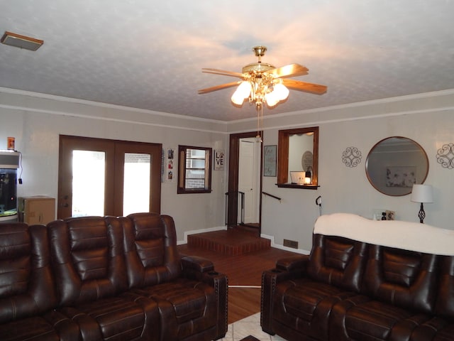 living room featuring hardwood / wood-style floors, a textured ceiling, ceiling fan, and ornamental molding