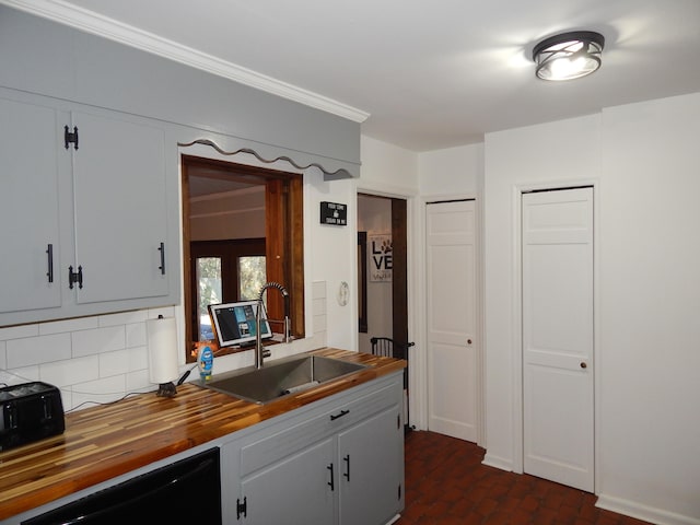 kitchen with dishwasher, backsplash, wood counters, and sink