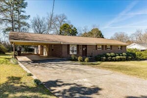 view of front of property featuring a front lawn and a carport