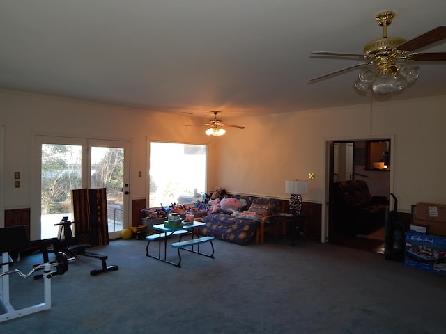 living room with carpet, ceiling fan, and crown molding