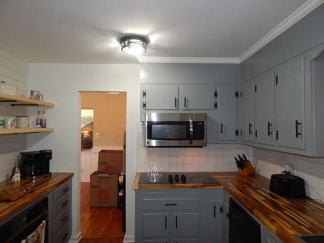 kitchen with tasteful backsplash, crown molding, black appliances, gray cabinets, and butcher block countertops