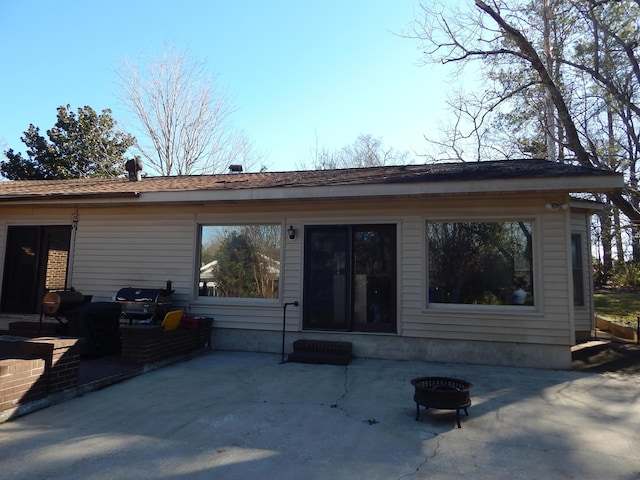 rear view of house with a patio and an outdoor fire pit