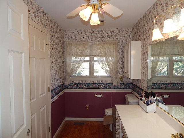 bathroom with hardwood / wood-style floors, ceiling fan, toilet, and vanity