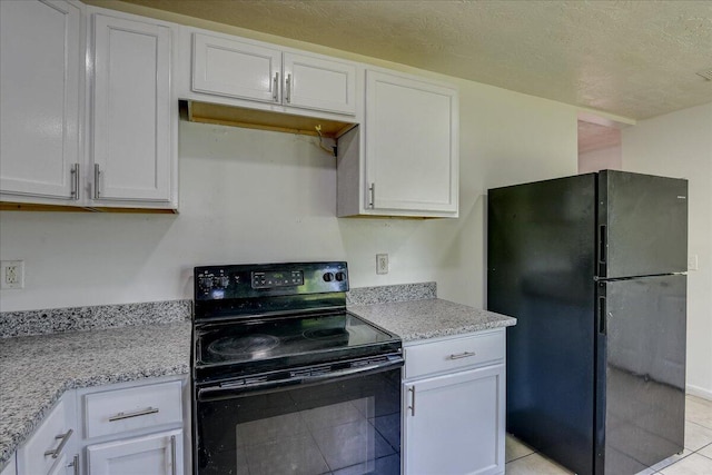 2028 Wharton Dr, Augusta, GA 30904 - kitchen featuring black appliances, light tile patterned flooring, white cabinets, light stone counters, and a textured ceiling