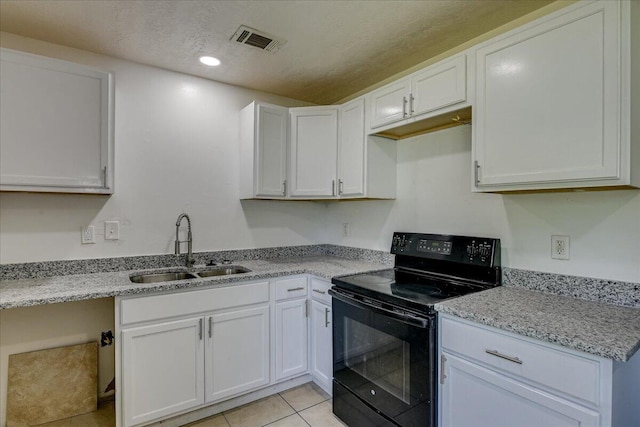 2028 Wharton Dr, Augusta, GA 30904 - kitchen with black electric range, white cabinets, a textured ceiling, light tile patterned flooring, and recessed lighting