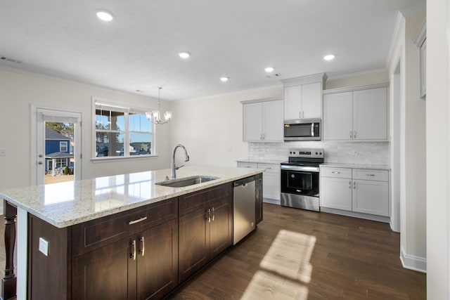 kitchen with pendant lighting, appliances with stainless steel finishes, dark wood-type flooring, sink, and a notable chandelier