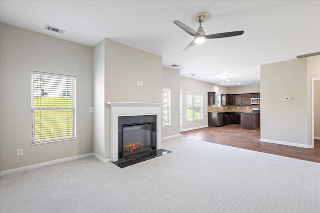 unfurnished living room featuring carpet flooring and ceiling fan