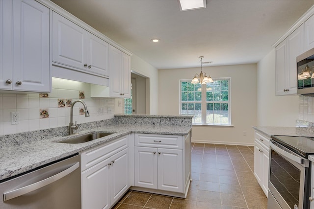 kitchen featuring appliances with stainless steel finishes, a sink, tasteful backsplash, white cabinetry, and recessed lighting