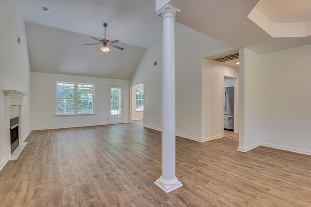 unfurnished living room featuring a ceiling fan, ornate columns, high vaulted ceiling, wood finished floors, and baseboards