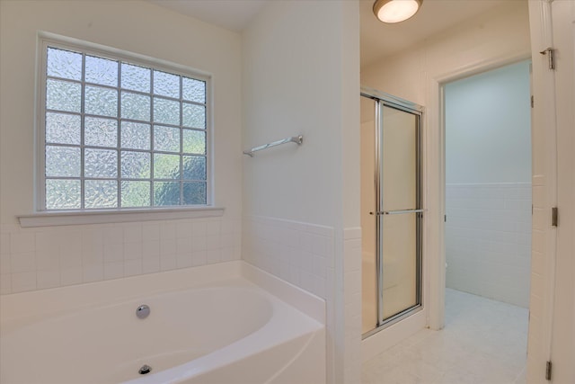 bathroom with a stall shower, a garden tub, and tile patterned floors