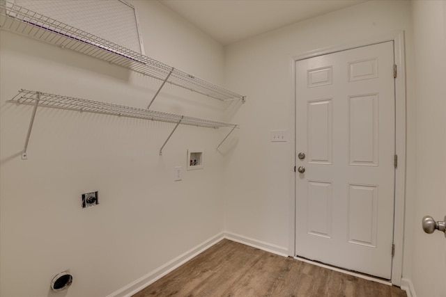laundry area with hookup for an electric dryer, hookup for a washing machine, wood finished floors, and baseboards