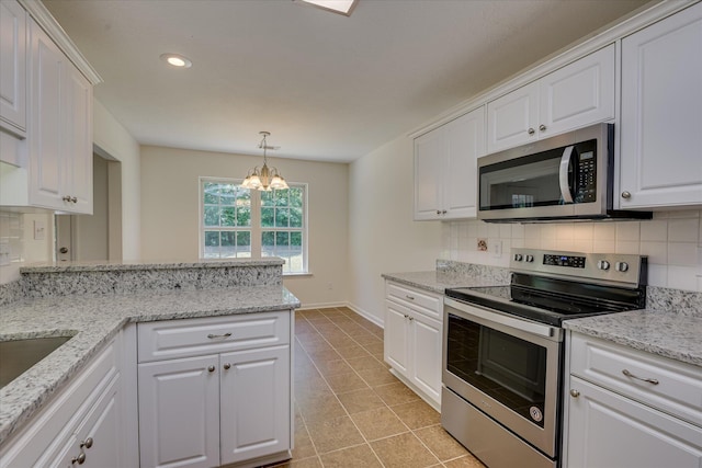 kitchen featuring stainless steel appliances, a chandelier, white cabinetry, backsplash, and light tile patterned flooring