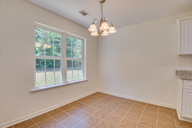 unfurnished dining area with a chandelier and baseboards