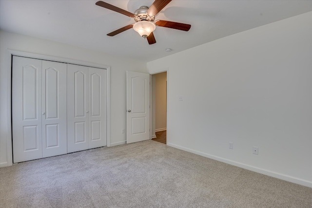 unfurnished bedroom with carpet floors, baseboards, a closet, and a ceiling fan
